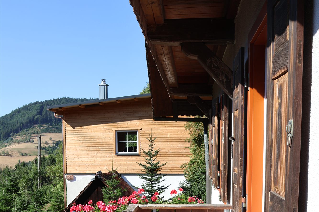 Balkon mit Holzgeländer und Fensterläden